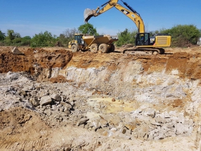 Machine en train de creuser les fondations le site du futur bâtiment du groupe Elis
