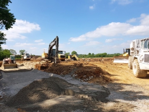 Pose de sable pour terrasser le site du futur bâtiment du groupe Elis